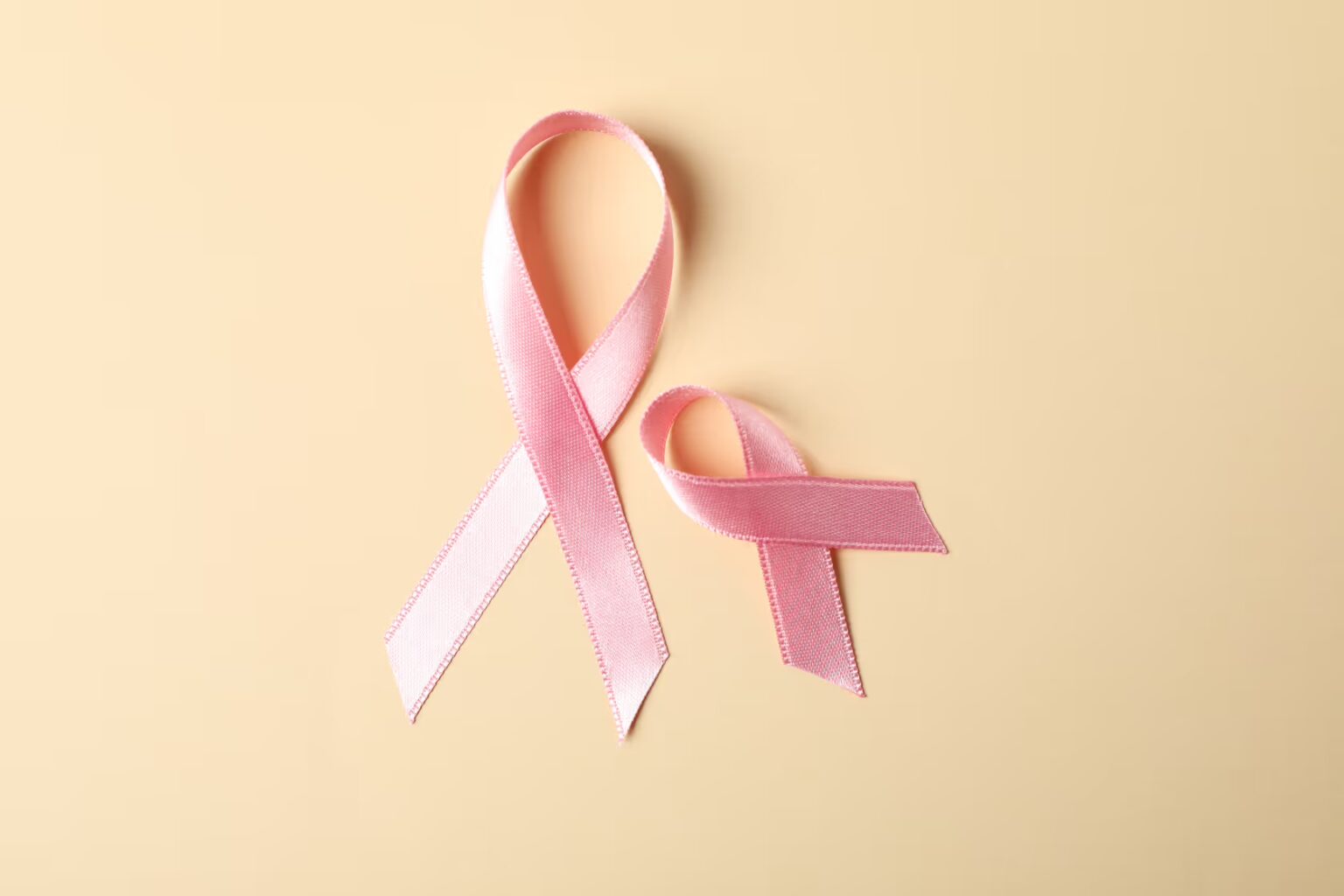 6704f8c81d054d3146e38471_pink-awareness-ribbons-on-color-background-space-2023-11-27-05-11-30-utc (1)